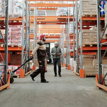 Opérateurs en préparation de commandes dans une allée d’entrepôt